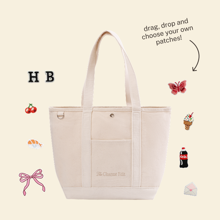 An off-white canvas tote bag from The Charmé Edit shown with patch illustrations, ready to be personalised