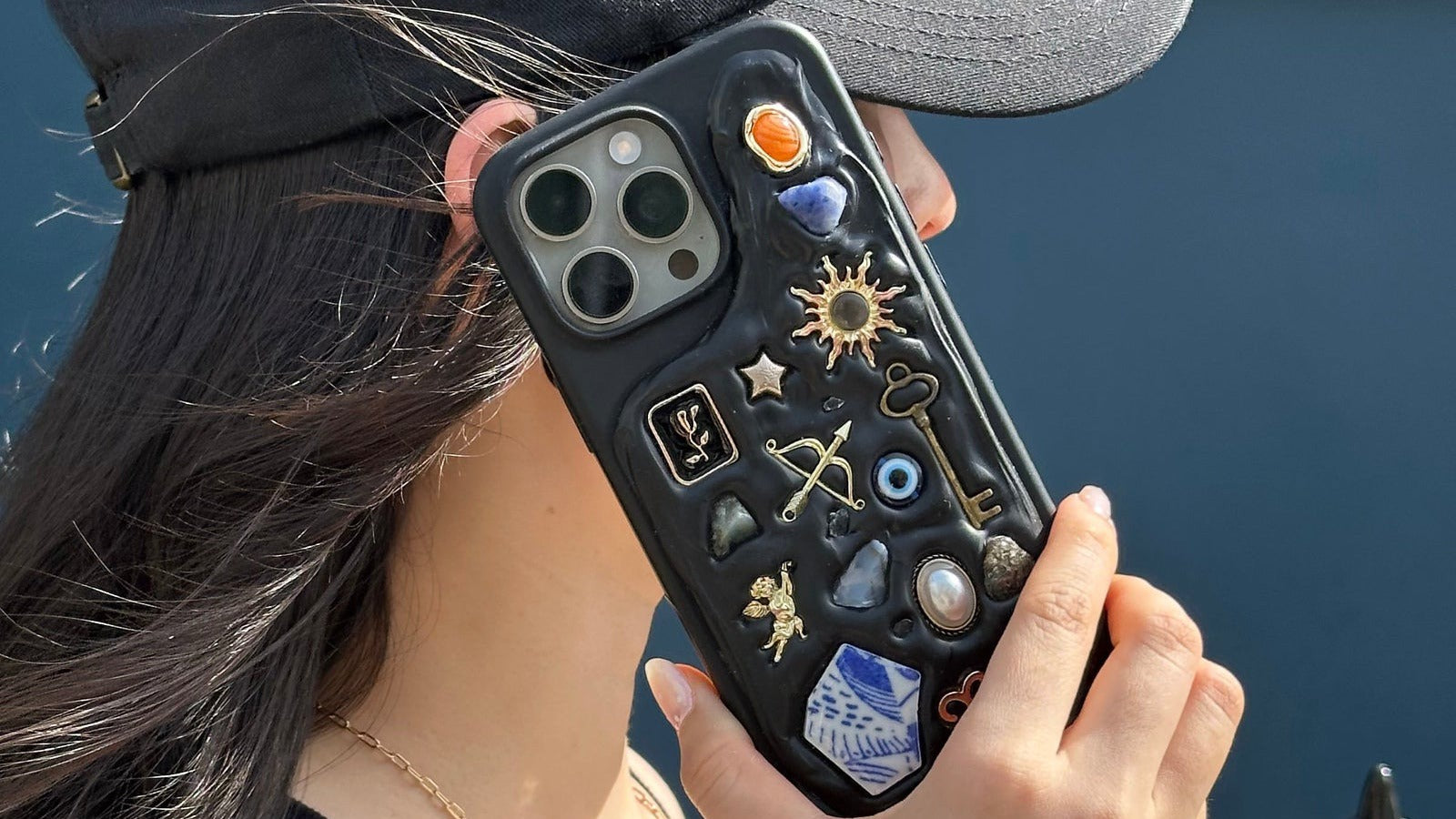 Personalised charm phone case with sun, key, and evil eye charms from The Charmé Edit