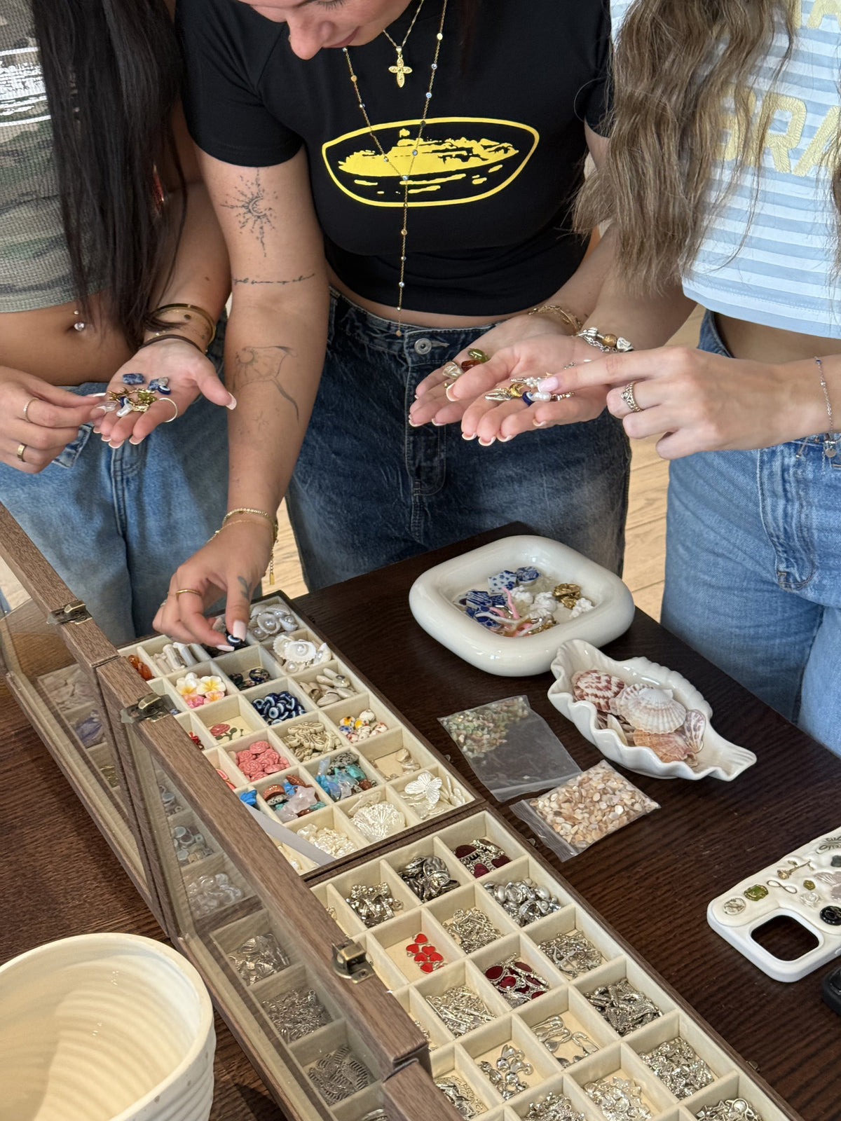 Charms including an evil eye laid out at a private Charmé Edit workshop table