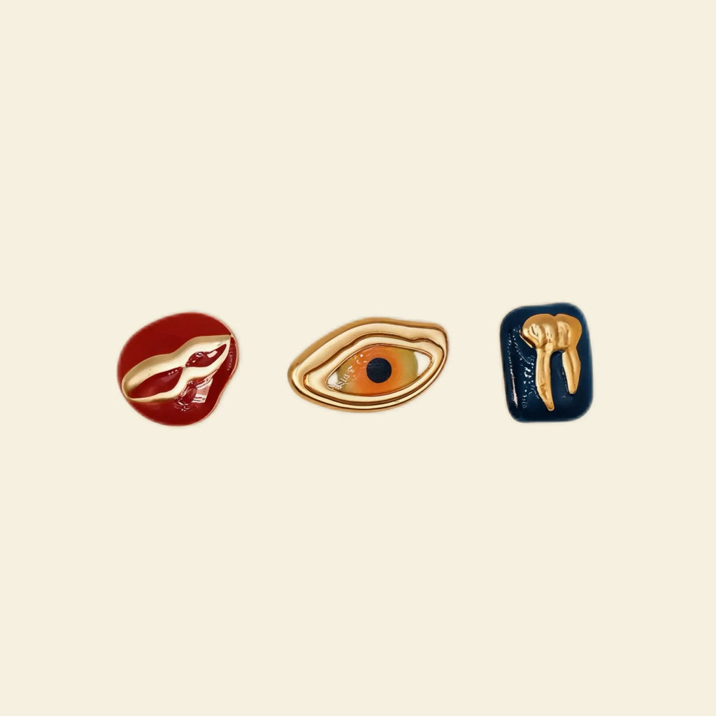 custom phone case accessories: gold eye, tooth, and lip charms for phone cases.