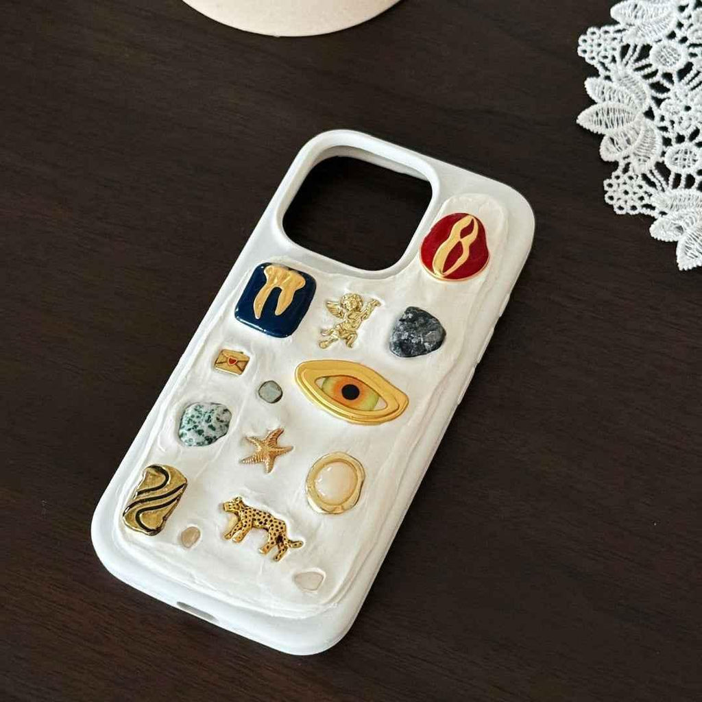 Phone case with various decorative pins on a wooden surface