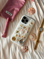 handmade personalised iPhone 17 Pro case with shell charms in lifestyle flat lay, coastal aesthetic gift