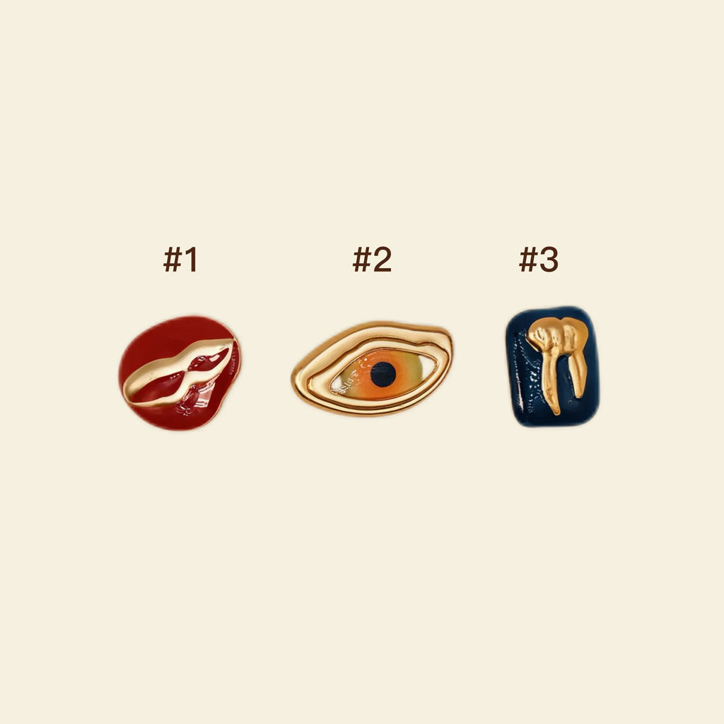 custom phone case accessories: gold eye, tooth, and lip charms for phone cases.