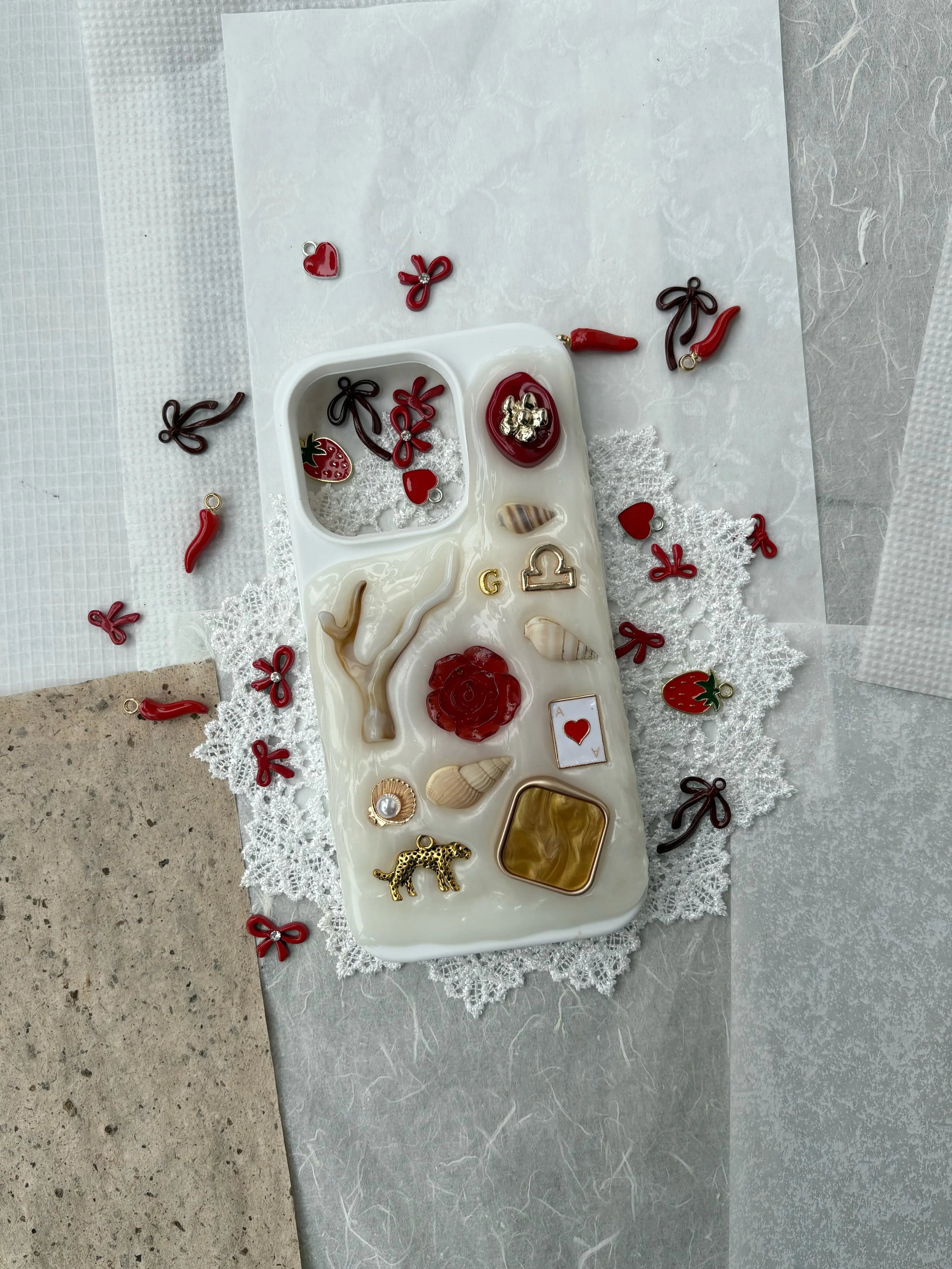 coquette style phone case with red bow and strawberry charms, handmade custom phone case