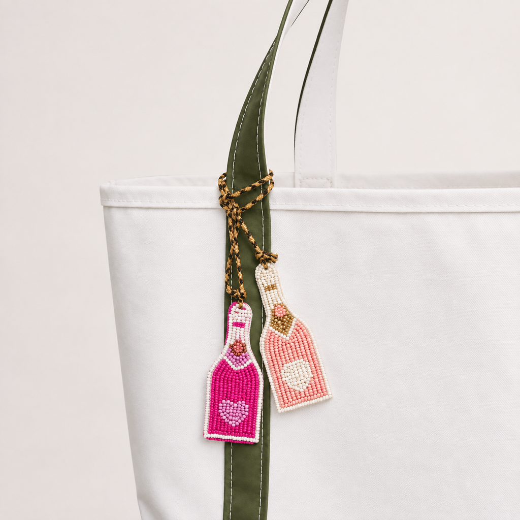 Handmade beaded bottle bag charms tied to a white tote bag