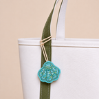 The Côte Shell hand-beaded shell bag charm tied to a white tote