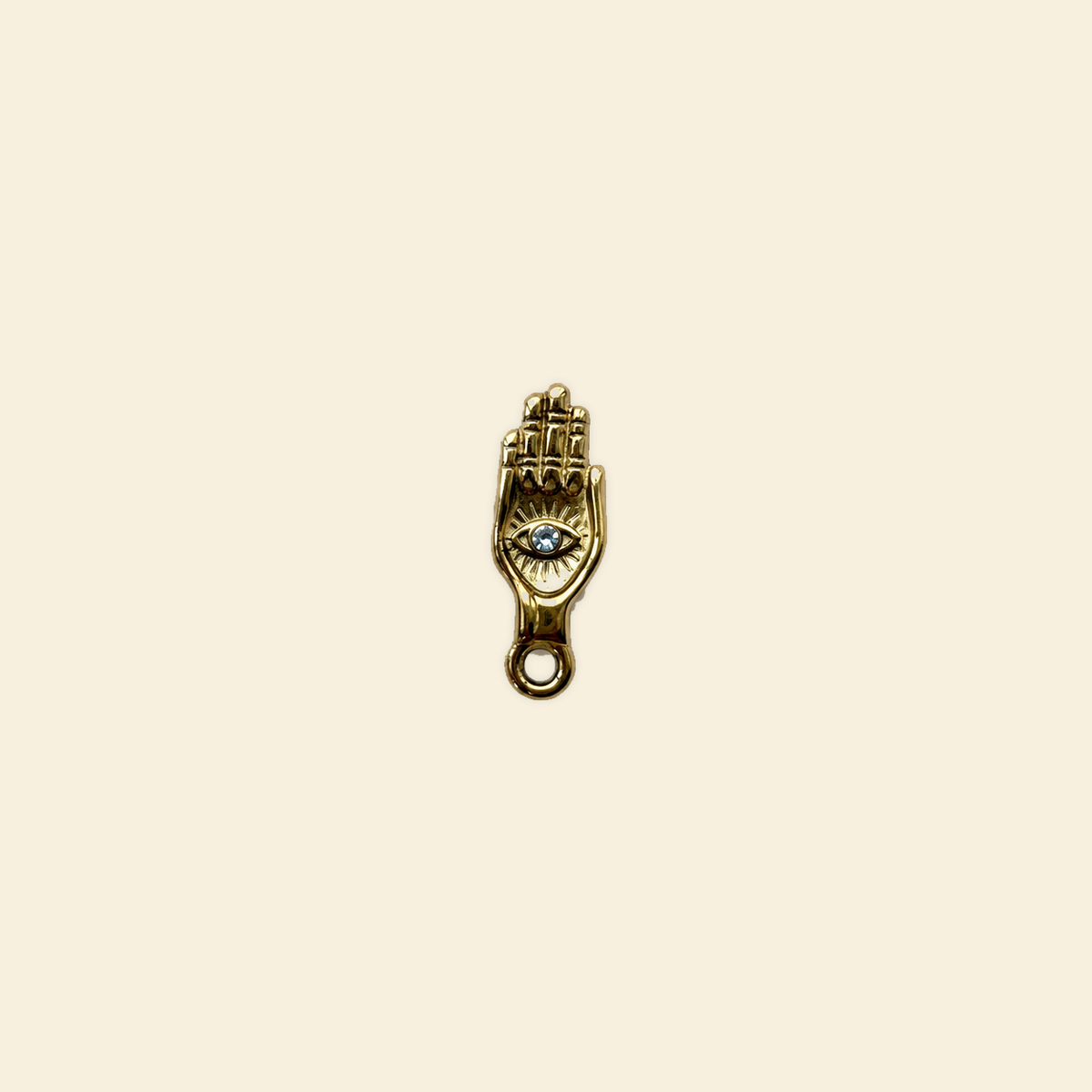 hamsa charm on a solid #f7f0df background