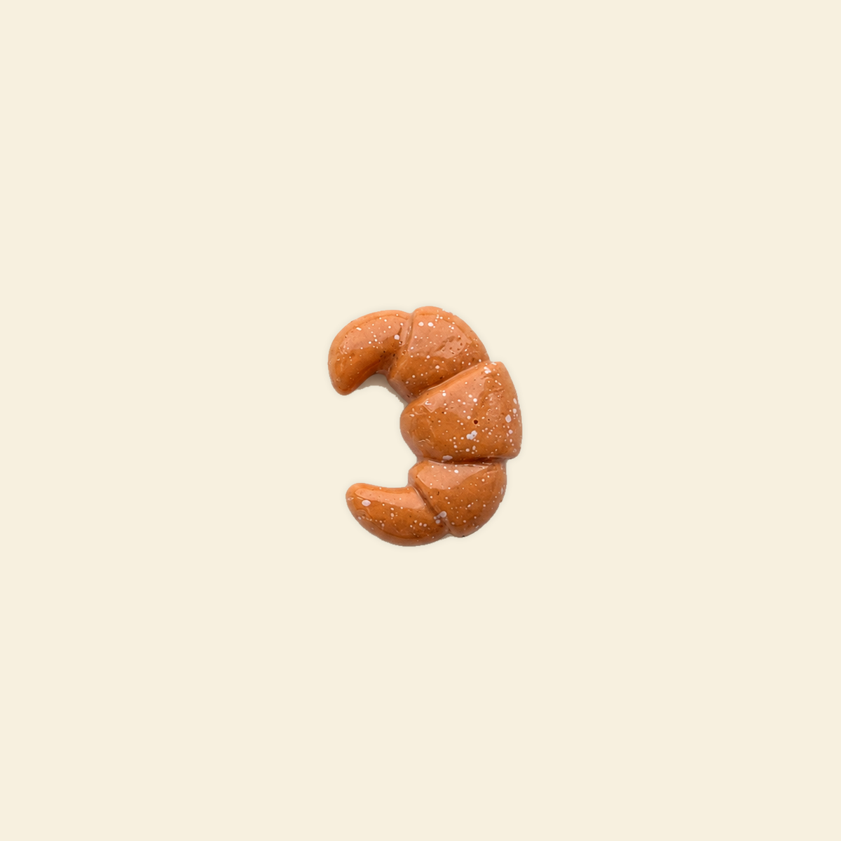 croissant charm on a solid #f7f0df background