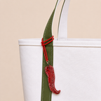 The Hot Stuff hand-beaded red chilli bag charm tied to a white tote