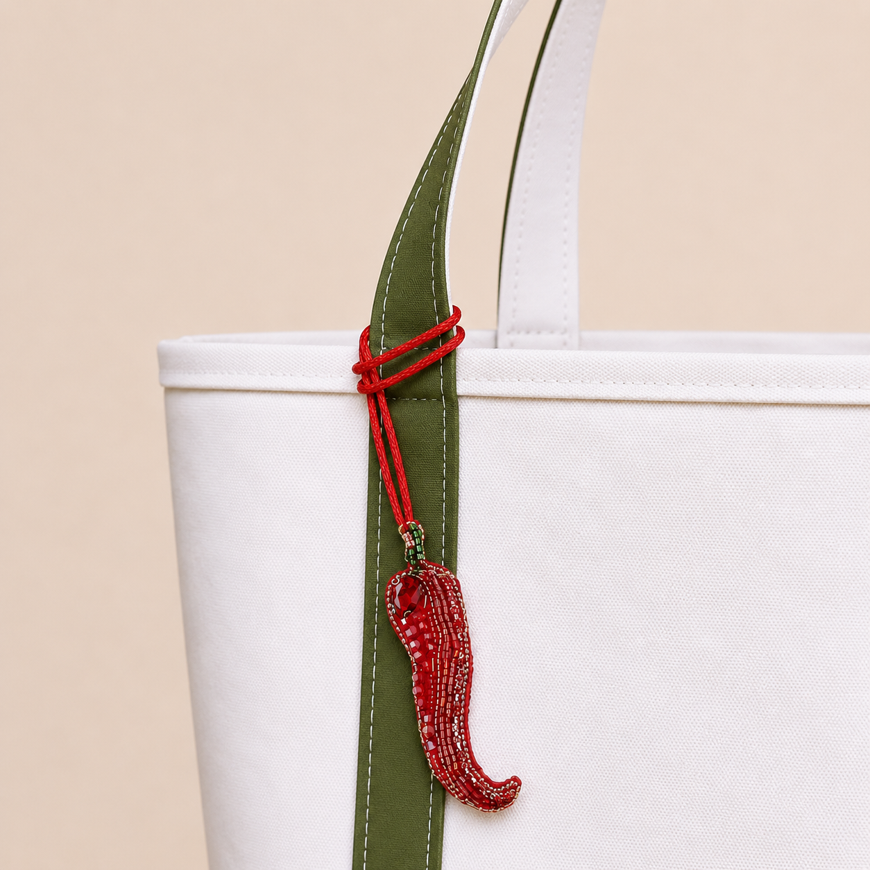 The Hot Stuff hand-beaded red chilli bag charm tied to a white tote